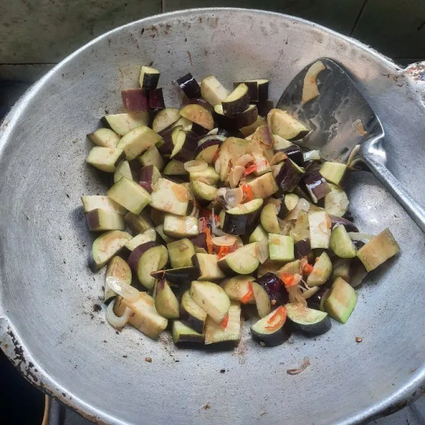 Masukkan terong lalu tambah sedikit air, aduk sampai terong setengah matang.