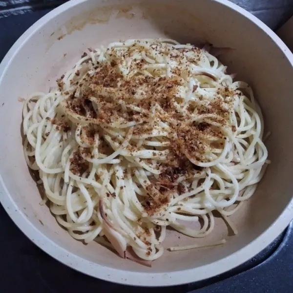 Masukkan spaghetti, aduk, tambahkan bubuk cabe dan kaldu bubuk, aduk hingga rata, masak dengan api kecil, koreksi rasa.
