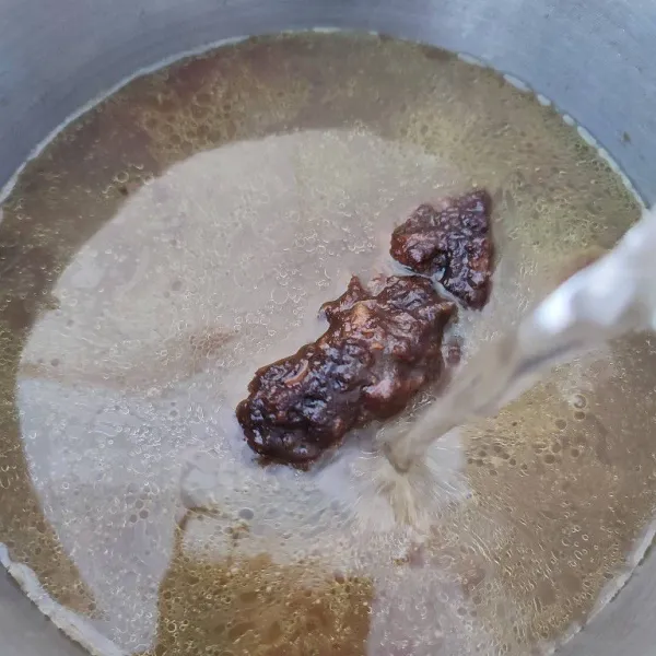 Kemudian masukkan tumisan bumbu ke dalam air rebusan daging dan tambahkan sisa air.