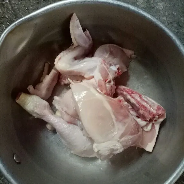 Pertama potong-potong ayam menjadi beberapa bagian kemudian cuci bersih.
