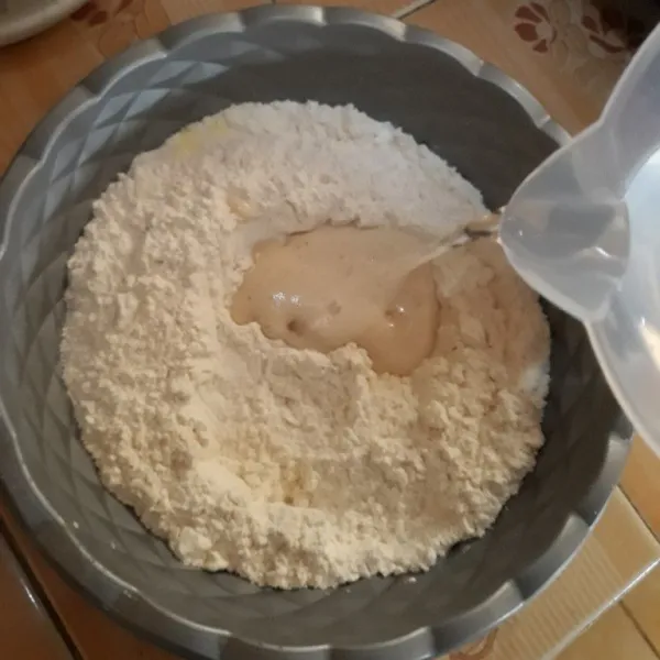 Tambahkan adonan biang yang sudah mengembang dan air sedikit demi sedikit sambil diaduk.