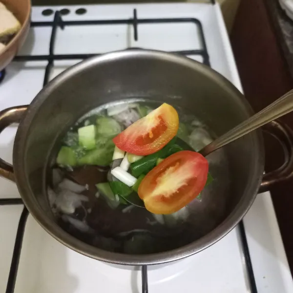 Masukkan irisan bawang daun dan tomat.