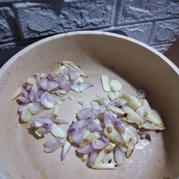 Panaskan minyak dengan api kecil, masukkan irisan bawang putih dan bawang merah, tumis.