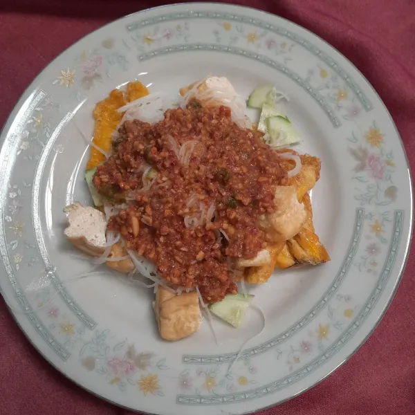 Masukkan dalam piring tahu, telur goreng, bihun dan timun, beri kuah kacang dan siap disajikan.