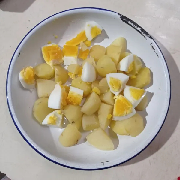 Potong potong kentang dan telur rebus, pindahkan kepiring.