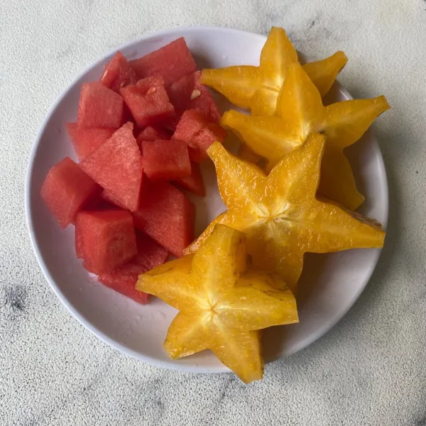 Kupas dan potong buah semangka. Buang bagian tepi buah belimbing, cuci bersih lalu potong-potong.