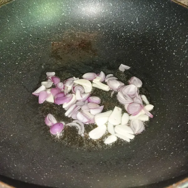 Iris tipis bawang merah dan bawang putih sampai harum dan layu.
