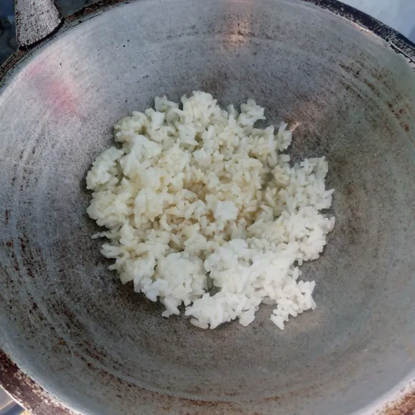 Siapkan minyak panas kemudian masukkan nasi, aduk rata.