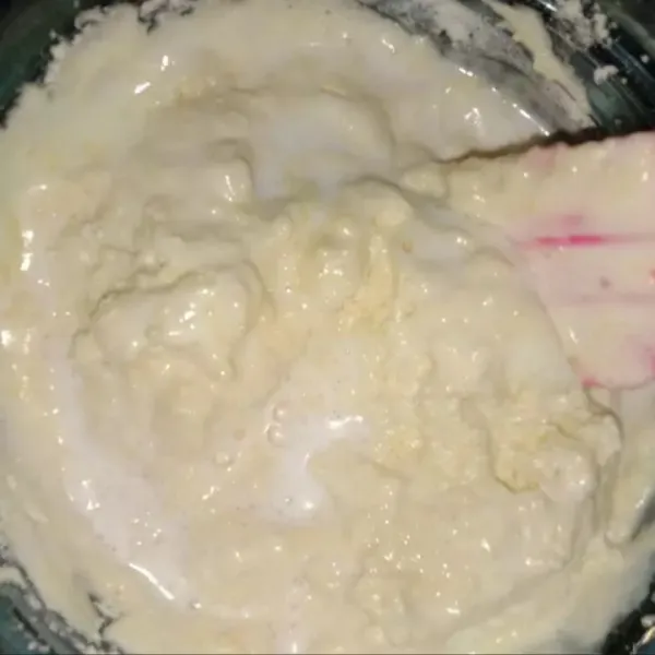 Masukkan susu kental manis yang sudah dilarutkan dengan enam sendok makan air hangat. Tuang perlahan sambil diaduk rata