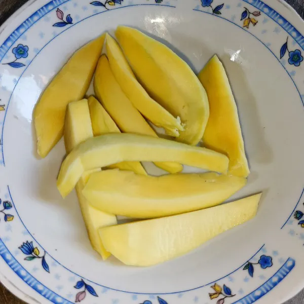 Kupas mangga dan potong-potong.