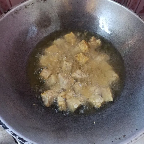 Potong dadu tempe kemudian goreng hingga setengah matang, setelah itu angkat dan tiriskan.