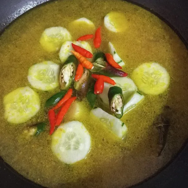 Masukkan timun, cabai hijau, dan cabai rawit, masak hingga timun setengah matang.