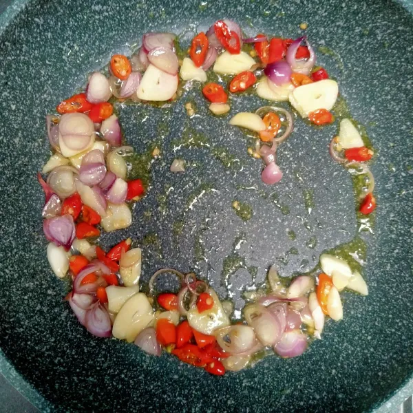 Panaskan minyak tumis bawang merah, bawang putih, dan cabai rawit.