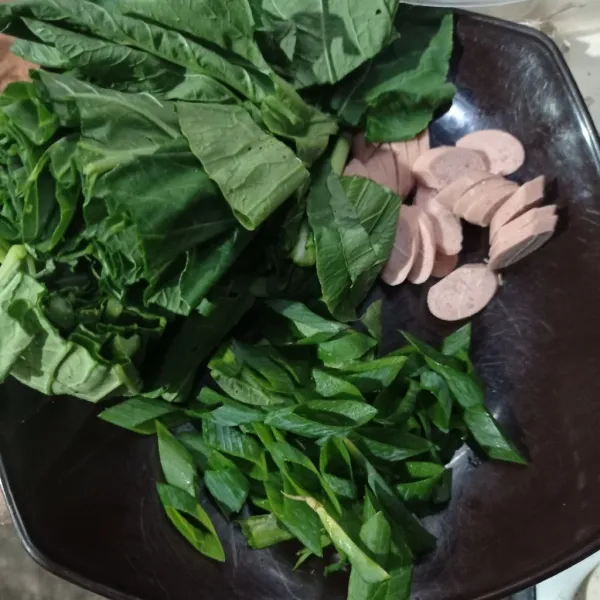 Iris caisim, daun bawang dan sosis.