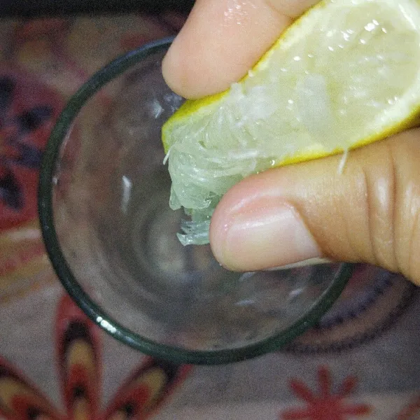 Dalam wadah, peras jeruk lemon dan tambahkan madu, aduk rata.