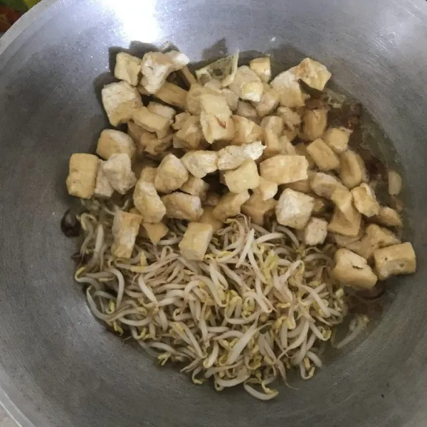 Tambahkan air, tahu yang sudah digoreng dan kecambah.