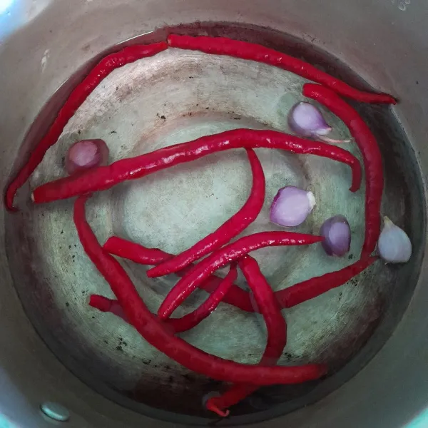 Masukkan ke dalam panci air, cabe merah, dan bawang merah.