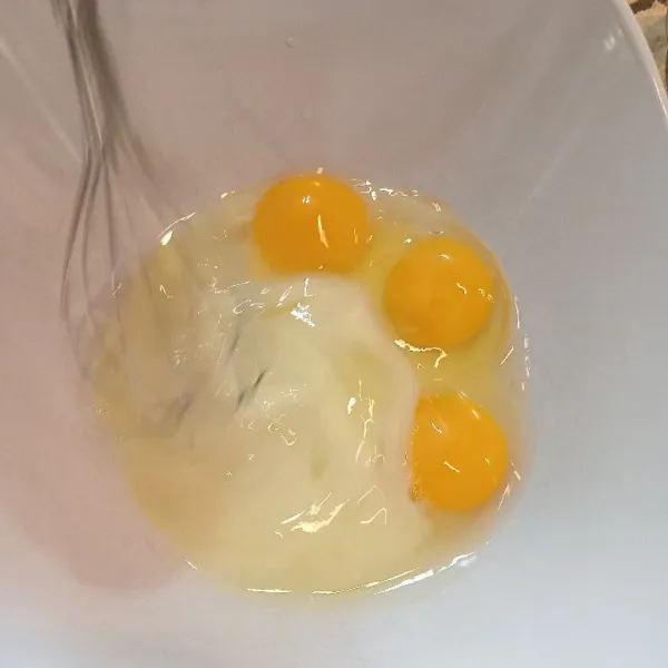 Kocok telur dan susu kental manis hingga tercampur rata menggunakan whisk atau garpu.