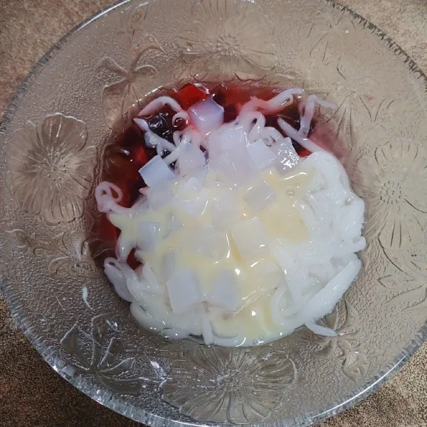 Masukkan semua bahan jelly ke dalam wadah, tambahkan nata de coco dan krimer kental manis.
