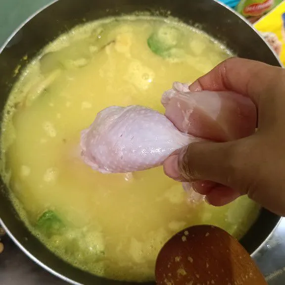 Setelah mendidih, masukkan ayam dan tempe, tambahkan garam, gula, dan kaldu bubuk, aduk rata.