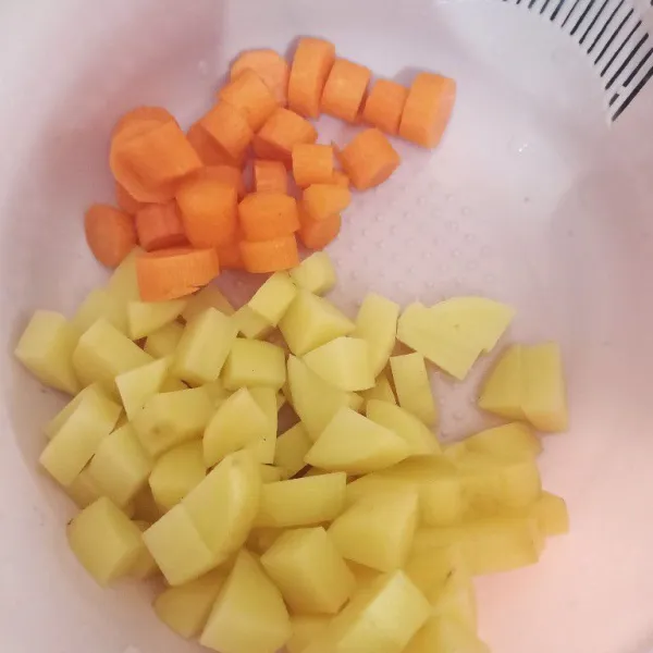 Kupas kulit dan potong kentang serta wortel, ukuran sesuai selera.