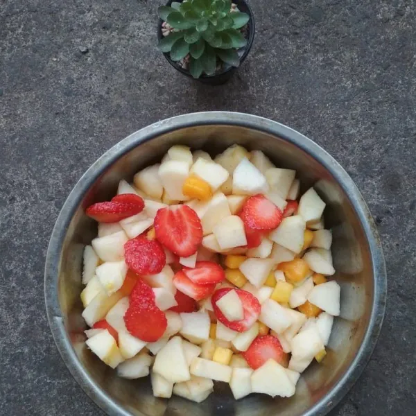 Kupas buah dan cuci bersih, rendam buah apel di air garam kemudian bila hingga bersih.