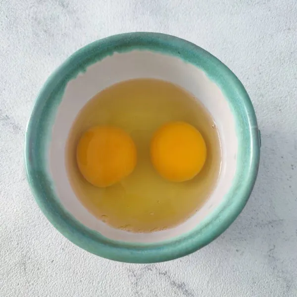 Pecahkan 2 butir telur, kemudian kocok lepas.