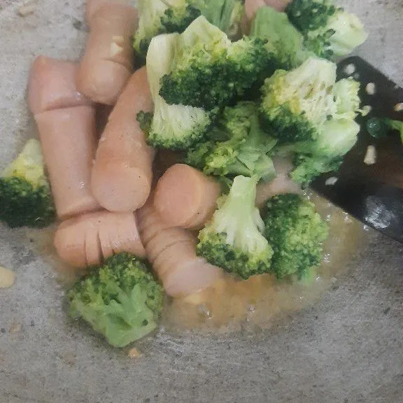 Masukkan sosis, tunggu sampai agak mekar, baru masukkan brokoli.