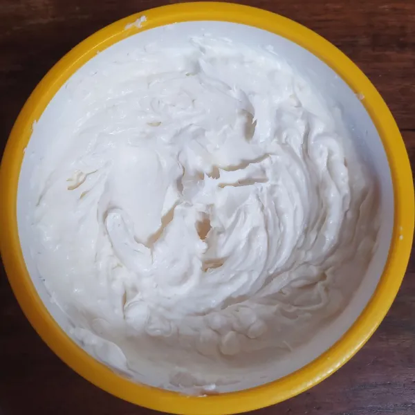 Campur whipped cream bubuk dengan air es lalu mikser sampai kaku dan kental berjejak.