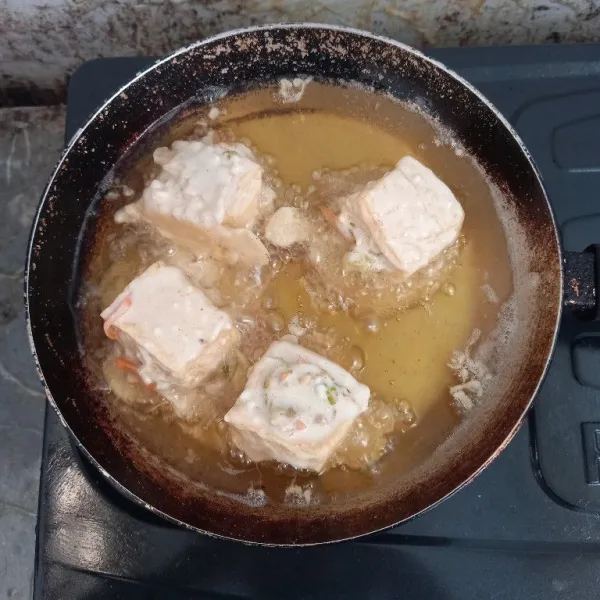Panaskan minyak, lalu goreng tahu yang sudah dibalurkan dengan adonan basah secara bersamaan.