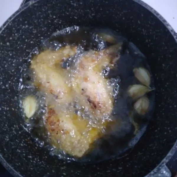 Panaskan minyak, goreng ayam setengah matang baru masukkan bawang putih. Masak sampai matang dengan api kecil sambil dibalik sesekali