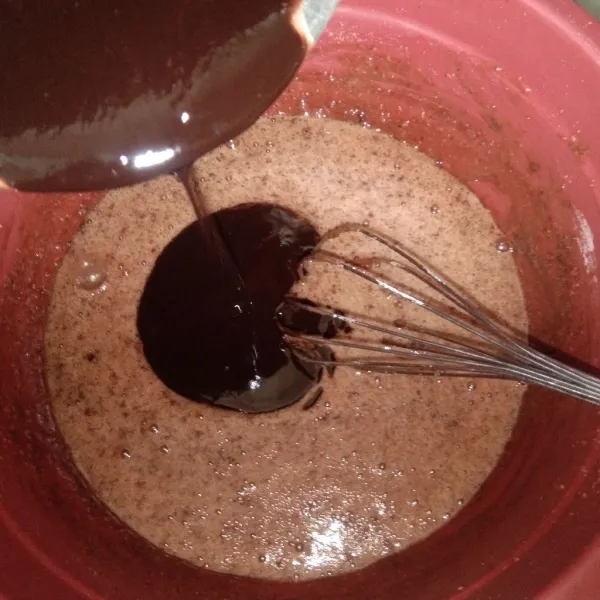 Masukkan cairan cokelat dan tepung secara bergantian kurang lebih tiga tahap sambil diaduk rata agar tidak ada yang mengendap