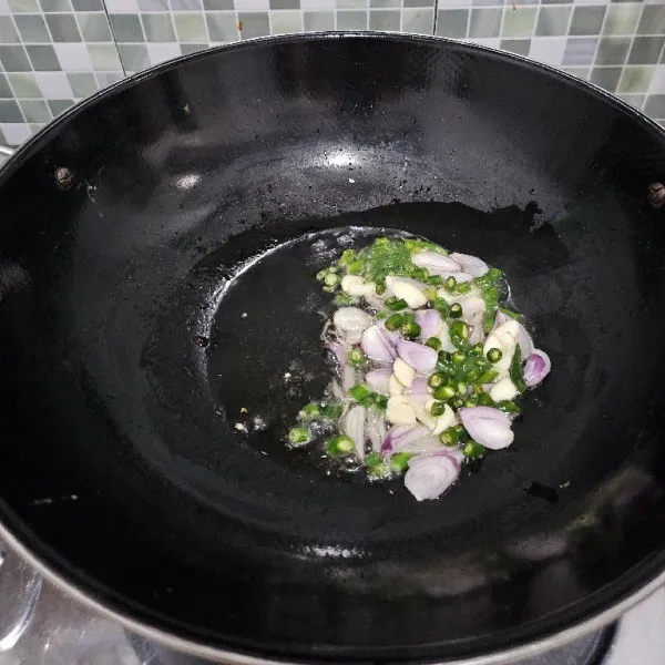 Tumis bawang merah dan bawang putih serta cabe rawit hingga harum.