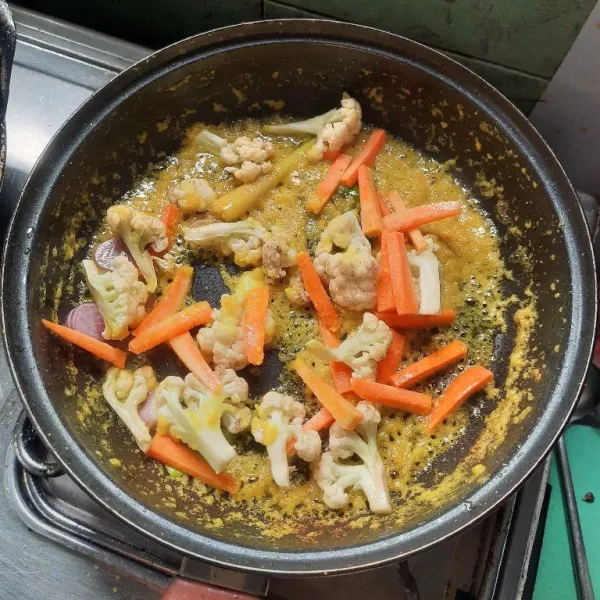 Masukkan kembang kol dan wortel, tambah air dan masak sampai agak empuk.