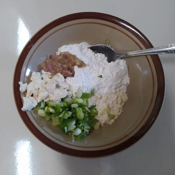 Siapkan mangkok, masukkan tepung tapioka, tepung terigu, bawang pre iris, sisa tahu (bagian tahu yang dikerok) dan bumbu halus.