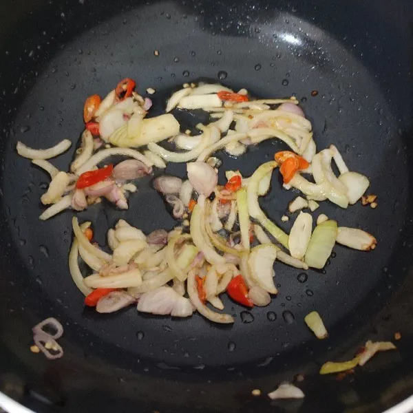 Tumis bawang bombai, bawang putih dan bawang merah dengan sedikit minyak goreng. Masak hingga bawang layu. Tambahkan cabe rawit, aduk rata.