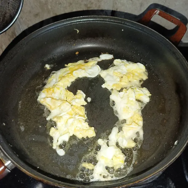 Panaskan minyak goreng dan masukkan telur, lalu buat telur orak-arik, angkat dan sisihkan.