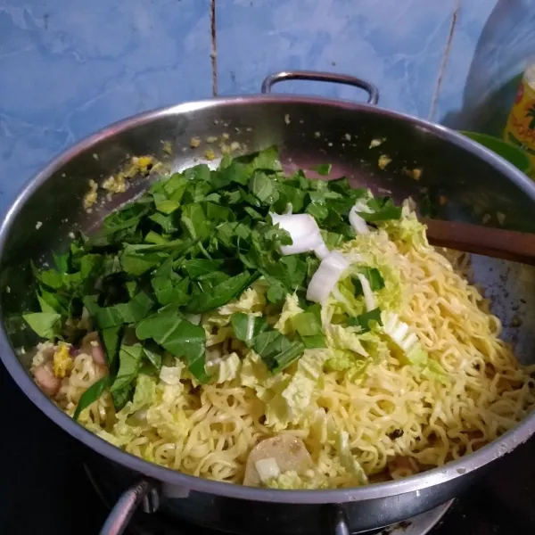 Masukkan mie dan sawi, aduk rata, masak sampai sayuran mulai layu.