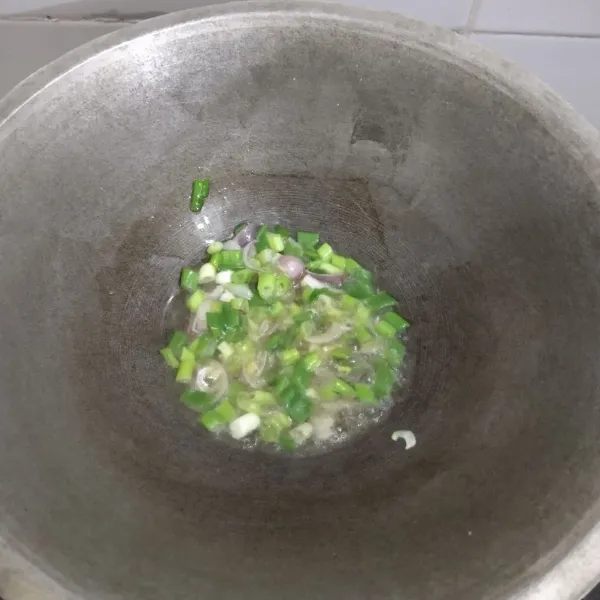 Panaskan minyak goreng, tumis bawang merah dan daun bawang sampai wangi.