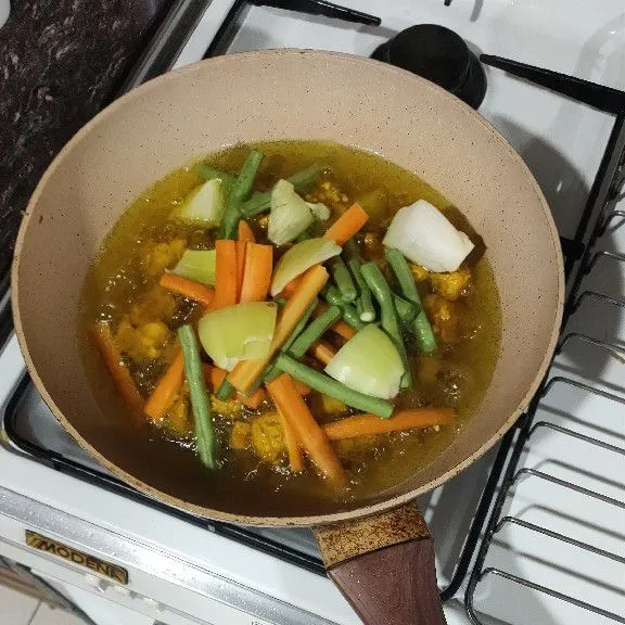 Ketika mulai kecokelatan, masukan sayur-sayuran. Aduk rata sampai sedikit layu. Matikan kompor dan angkat