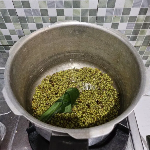 Masukkan kacang hijau, air, garam, dan daun pandan ke dalam panci presto
