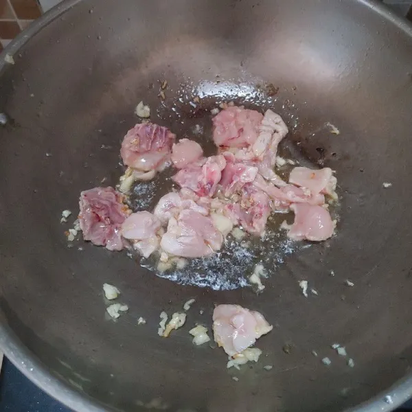 Tumis bawang putih hingga harum kemudian masukkan daging ayam. Aduk sampai ayam matang.