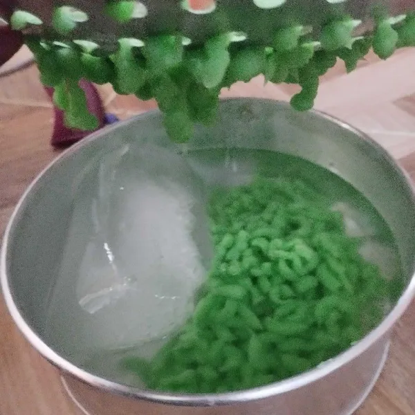 Tekan adonan cendol hingga keluar dan jatah di air es. Lakukan sampai adonan abis. Cendol dawet siap digunakan.