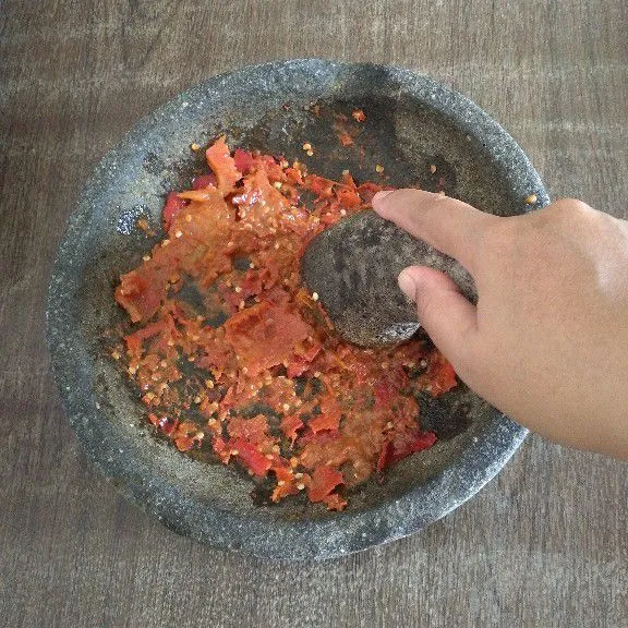 Tambahkan tomat iris lalu ulek kasar.