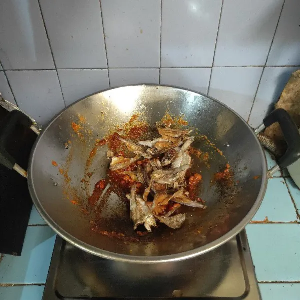 Masukkan kacang tanah goreng dan ikan bilis goreng, aduk rata dan gunakan api kecil.