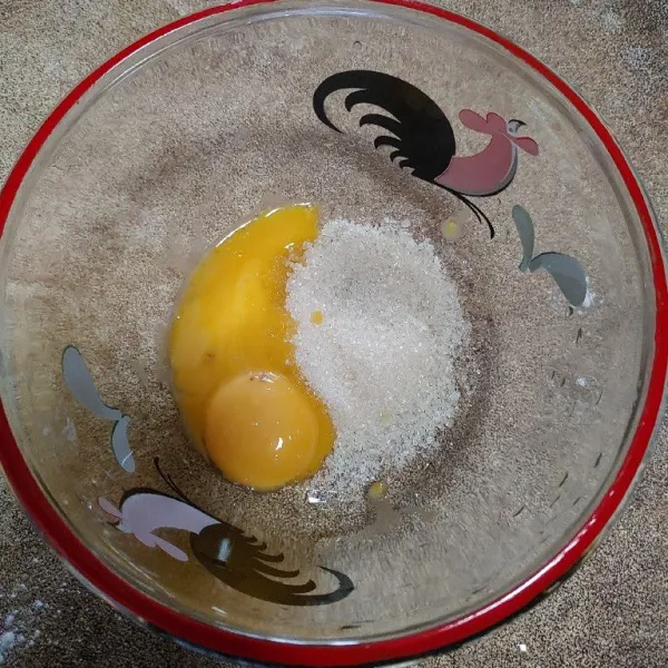 Masukkan kuning telur dan gula ke dalam wadah