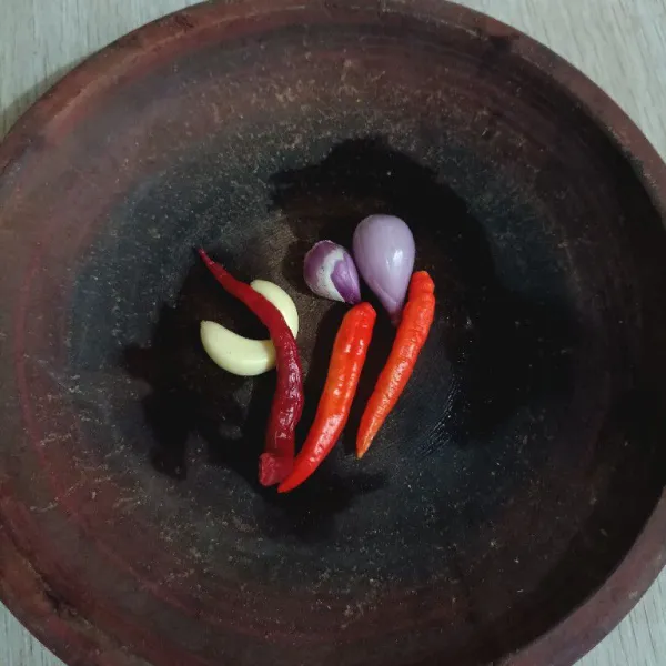 Kupas bawang merah dan bawang putih, buang tangkai cabai rawit dan cabai keriting.