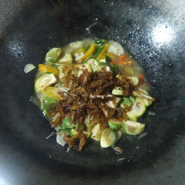 Setelah terong layu, masukkan ikan teri goreng, aduk rata dan masak sebentar, lalu angkat dan sajikan.