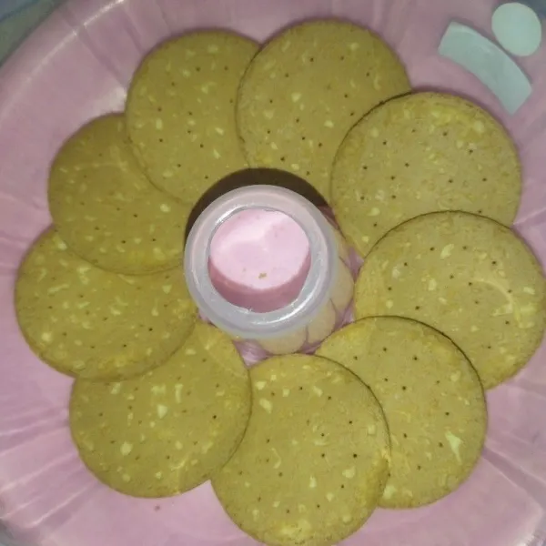 Siapkan cetakan puding, susun biskuit marie secukupnya.