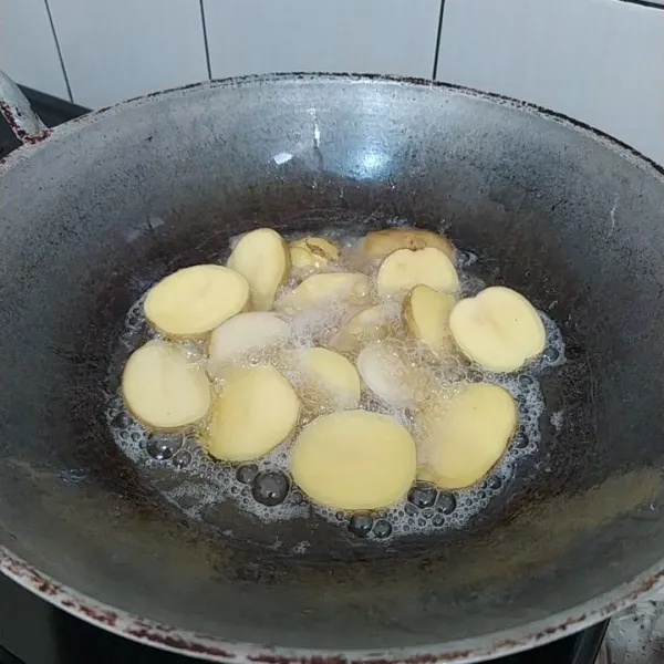 Cuci bersih kentang lalu potong-potong dan goreng hingga berkulit.
